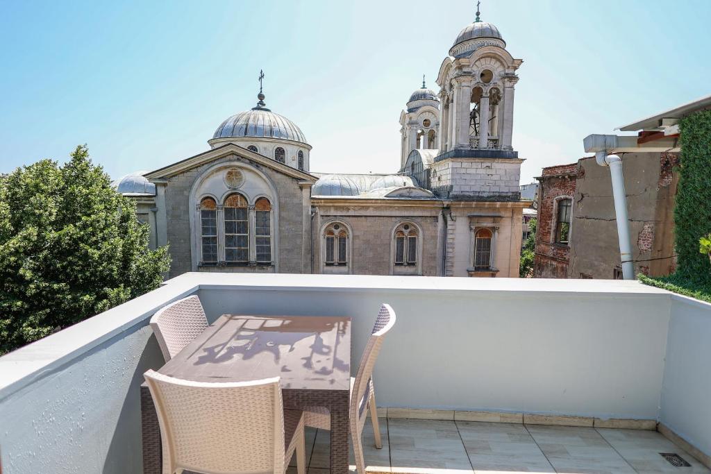 伊斯坦布尔Merdin Suites & Hotel - Downtown的阳台配有桌椅,与大楼相连