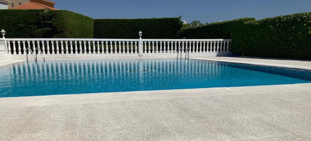 莫萨韦斯莫萨韦斯萨拉曼卡酒店的一个带白色围栏和蓝色水的游泳池