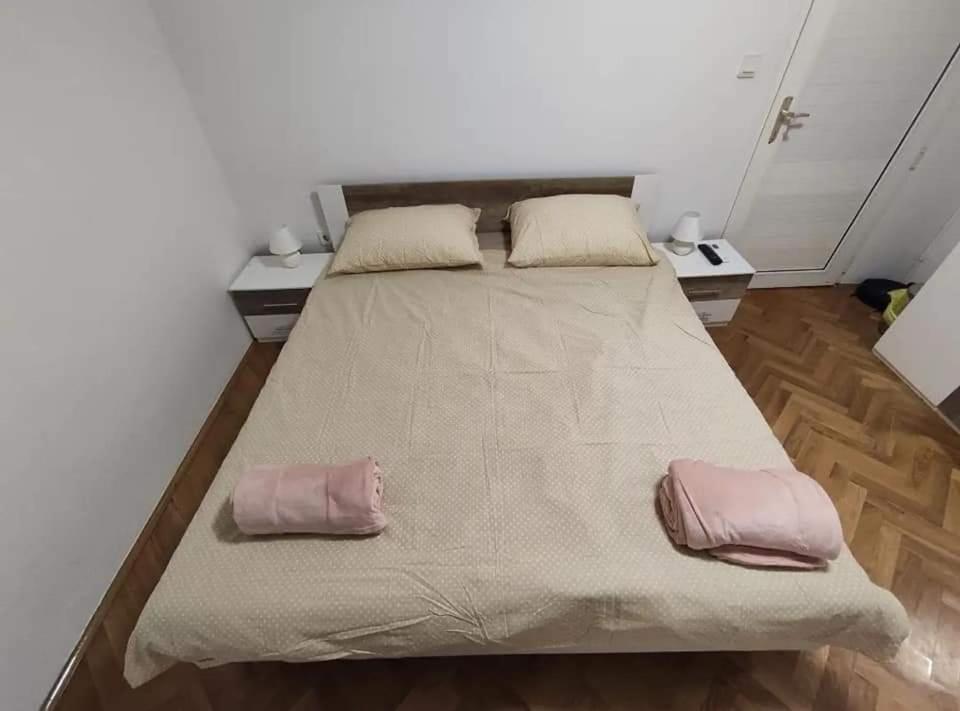 诺维·维诺多尔斯基Aretha apartman i sobe的一张大床,房间上有两个枕头