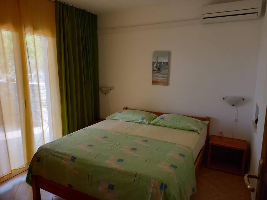 尼库加姆Apartments Belvedere - A3的一间卧室配有一张带绿色窗帘的床和窗户。
