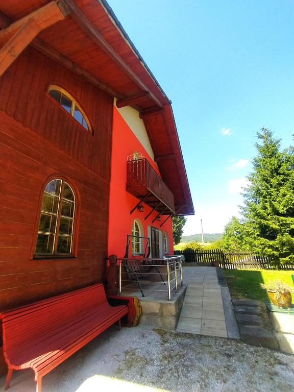 OhavečHaškovna - tradice zájezdního hostince u Prachovských skal的前面有长凳的红色建筑