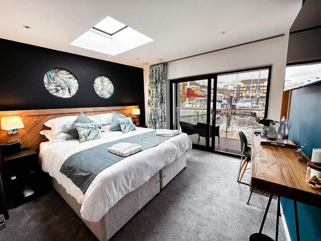 卡迪夫Rooms at The Deck, Penarth的一间卧室配有一张大床、一张书桌和窗户。