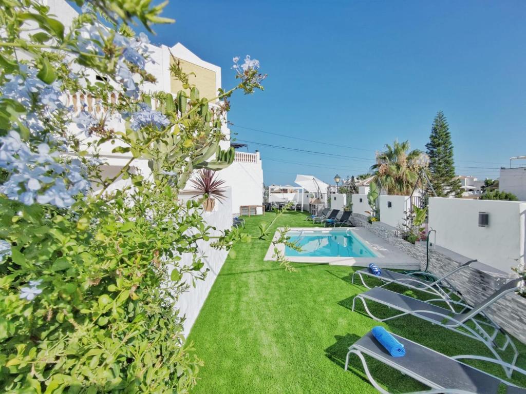 内尔哈Casa Higuera的后院设有游泳池和绿草