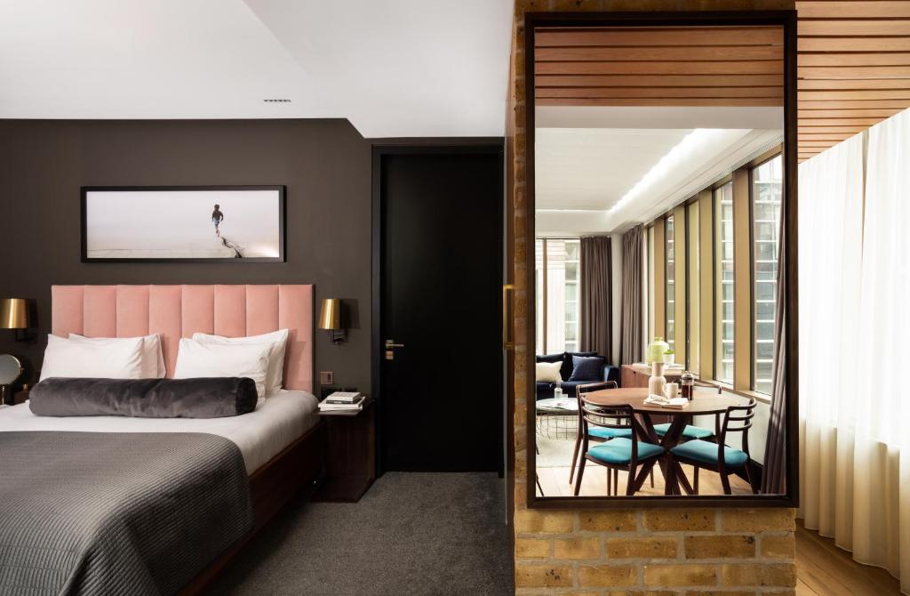 伦敦河岸本地公寓的酒店客房配有一张床铺和一张桌子。