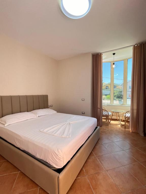 都拉斯Belix Hotel Apartments, Near the Beach的一间卧室设有一张床和一个大窗户