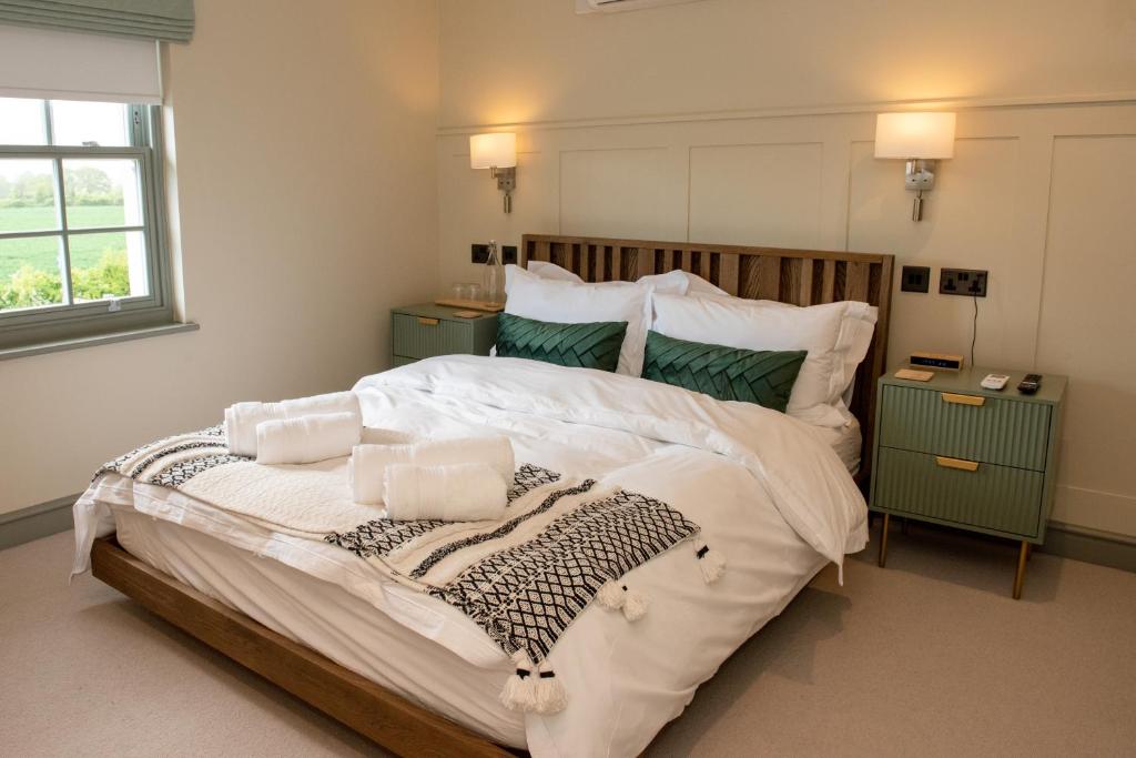 WivenhoeThe Flag的卧室配有一张带白色床单和枕头的大床。