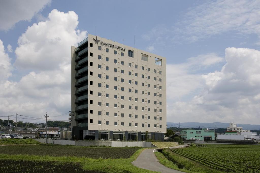 大洲大津熊本机场光芒酒店的田野中间高大的白色建筑