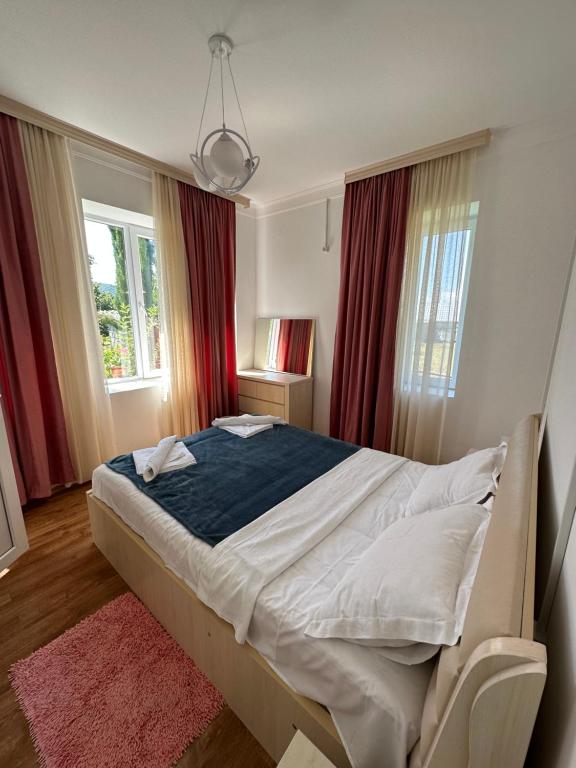 JoqoloLeila's Guest House的一间卧室配有一张带红色窗帘的大床
