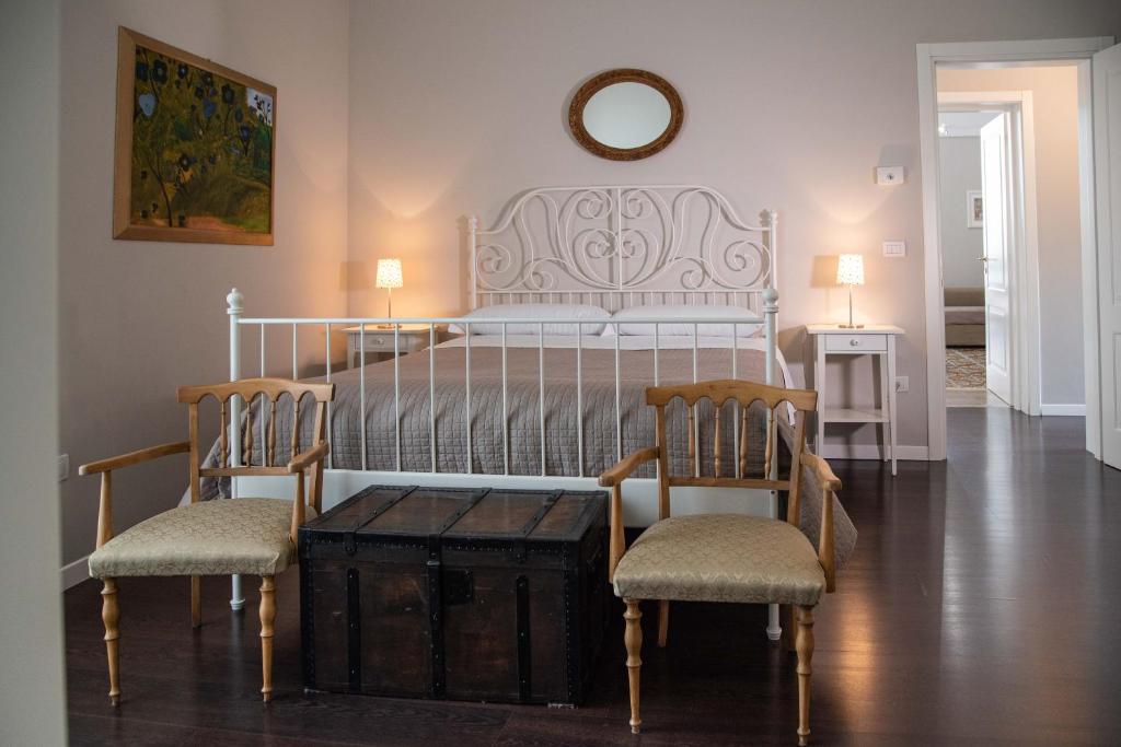 焦亚德尔科莱Dimora del Castellano的卧室配有白色的床、两把椅子和一张桌子