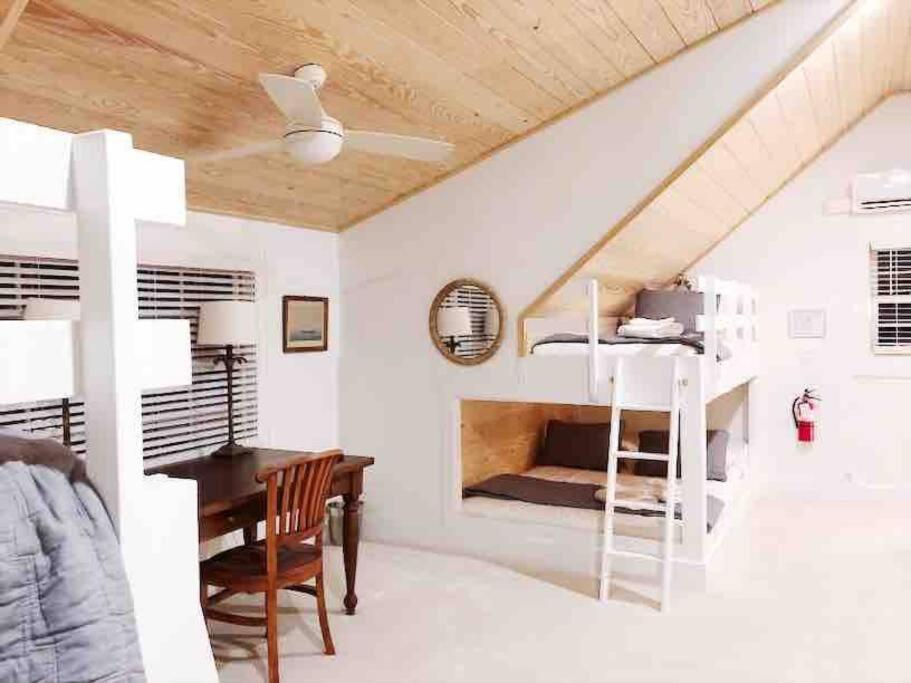 查尔斯顿Liz Lane Cottage- entire guesthouse的一间卧室配有一张桌子和一张双层床。