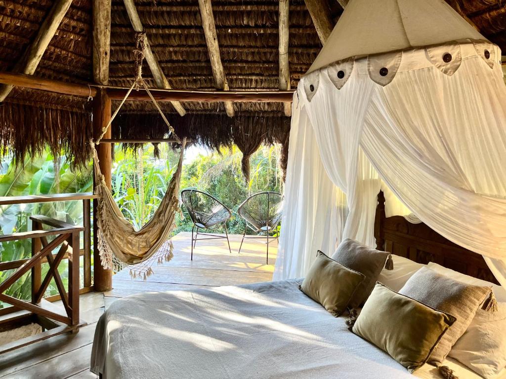阿布拉奥Jungle Lodge的度假村内带吊床的卧室