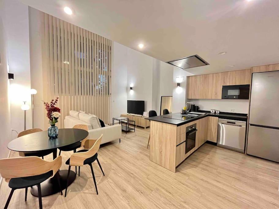 瓦伦西亚WeRentVLC - Espectacular Loft Duplex 1 hab的厨房以及带桌椅的起居室。