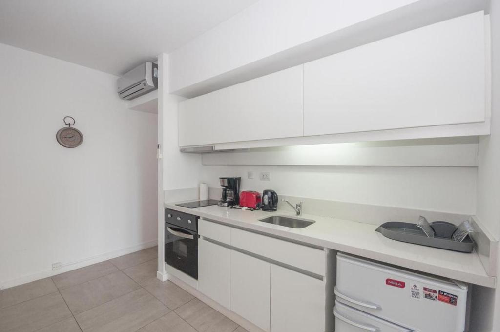 布宜诺斯艾利斯Libertador Complete Suite的白色的厨房设有水槽和炉灶。