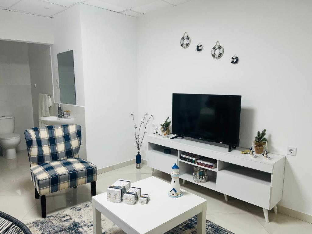 普拉亚Techas City Center Luxurious Suites & Rooms的客厅配有电视、椅子和桌子