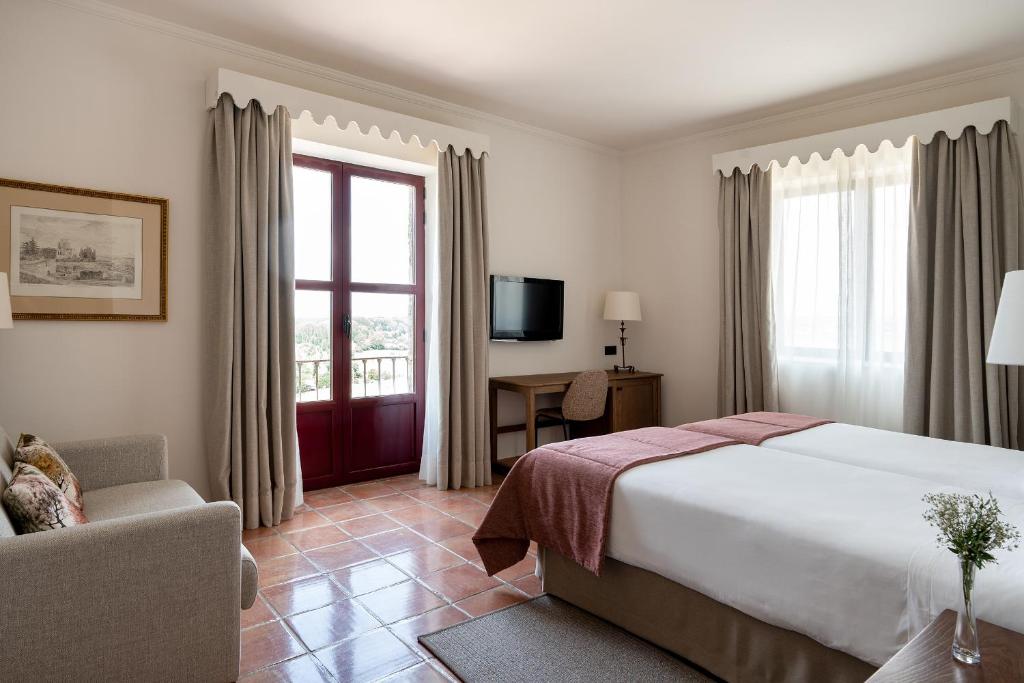 罗德里戈城罗德里戈城市旅馆的一间设有大床和窗户的酒店客房