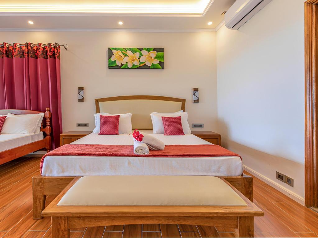 安塞奥潘美森迪阿岩旅馆的一间卧室配有一张带红色和白色枕头的大床