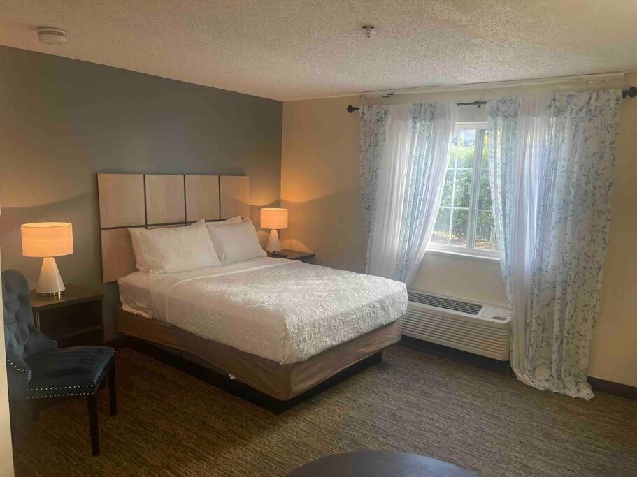 休斯顿Ultimate Escape/Free Parking的一间卧室设有一张床、一个窗口和一把椅子