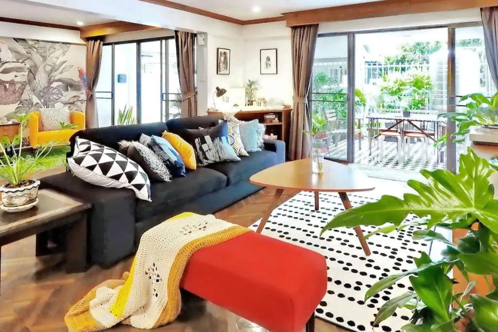 曼谷帕纳莱之家别墅的客厅配有蓝色沙发及色彩缤纷的枕头