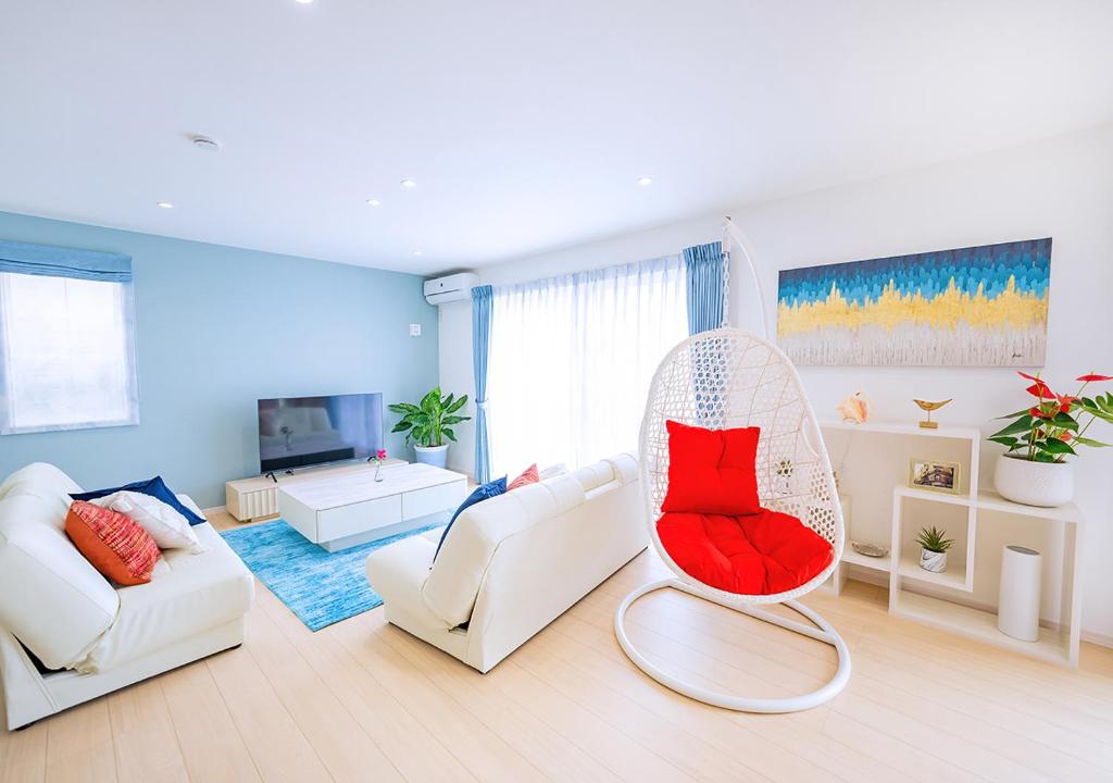 宫古岛ヴィラアマルフィ パームスプリングス宮古島リゾート的客厅配有白色家具和红色椅子
