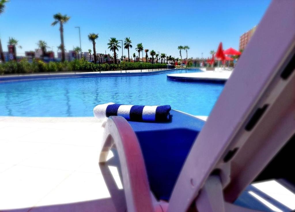 阿莱曼Prime chalet in Golf Porto Marina resort new Alamein的游泳池旁带躺椅的游泳池