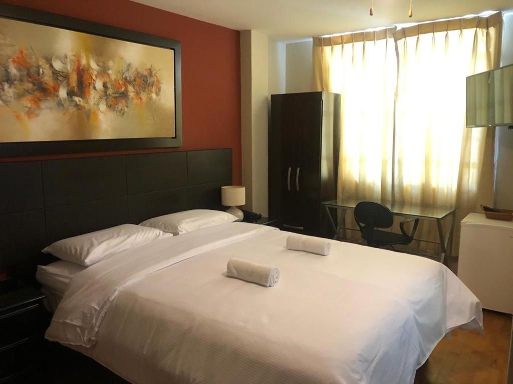 特鲁希略Hotel Las Condes的一间卧室配有一张大白色床和两个枕头