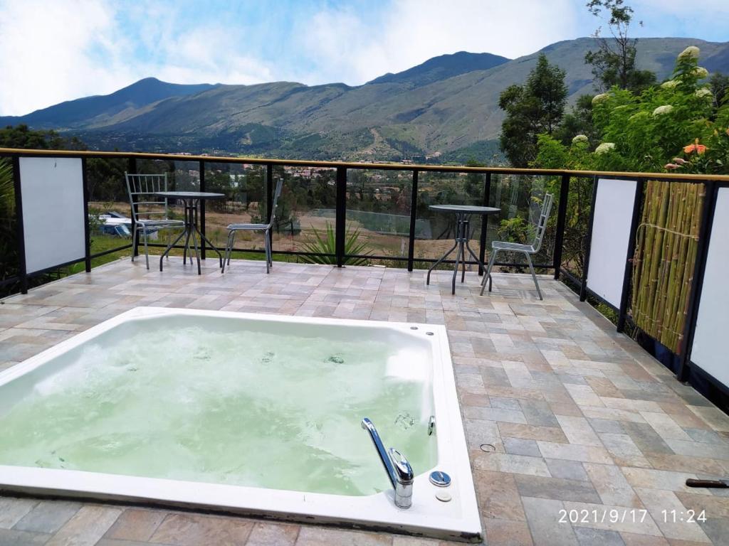 莱瓦镇Casa chalet Campestre 2km的庭院内的一个热水浴池,享有山脉背景