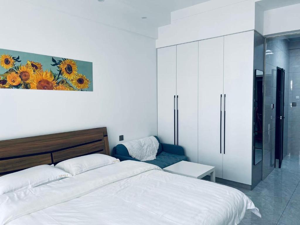 哈尔滨乌托邦酒店式公寓的卧室配有一张床,墙上挂有绘画作品