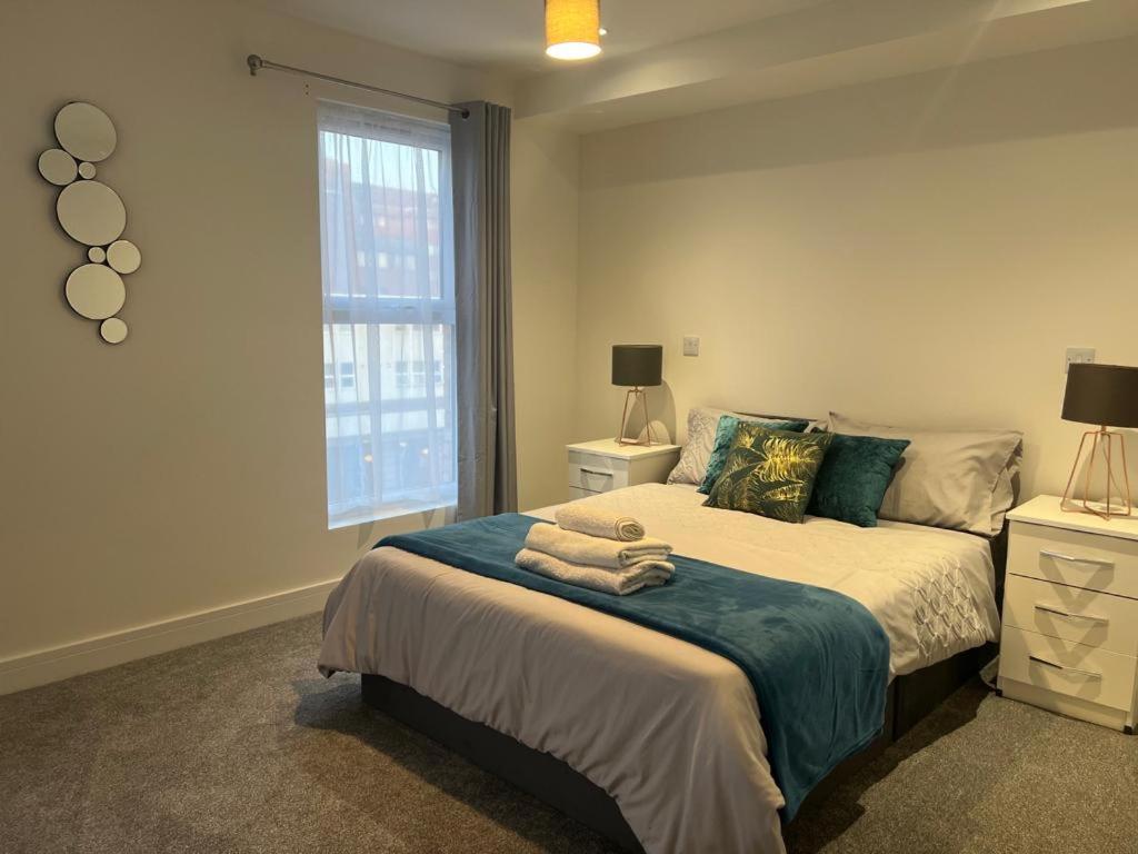 赫默尔亨普斯特德New modern 1 bedroom duplex apartment Hemel Hempstead High Street的一间卧室配有带毛巾的床