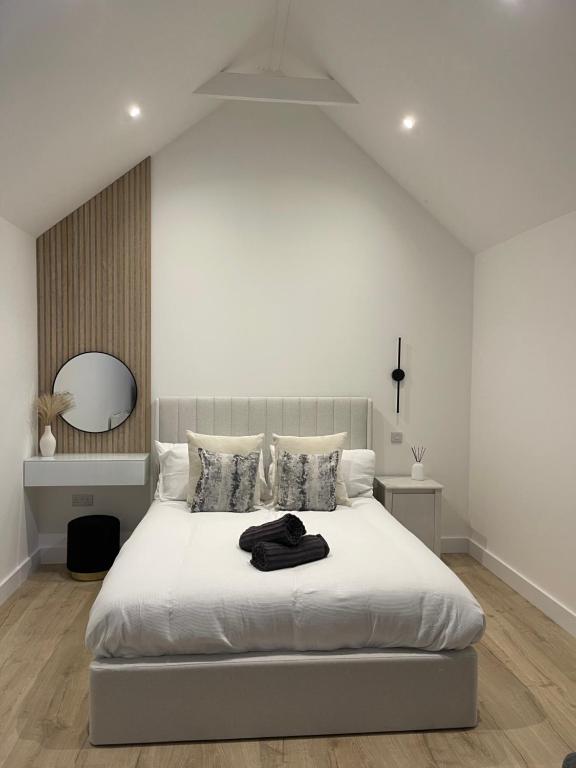 GurnardThe Lodge Hideaway in Cowes的白色卧室配有一张带镜子的大白色床