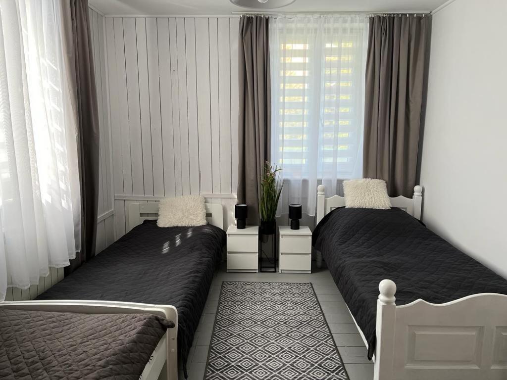 皮什Domek Mazury Pisz的卧室在窗户前配有两张床