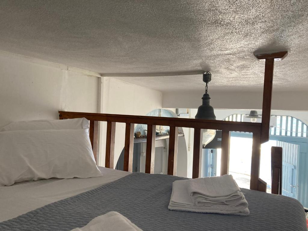 Klimathe monk seal boathouse的一间卧室配有一张床,床上有毛巾
