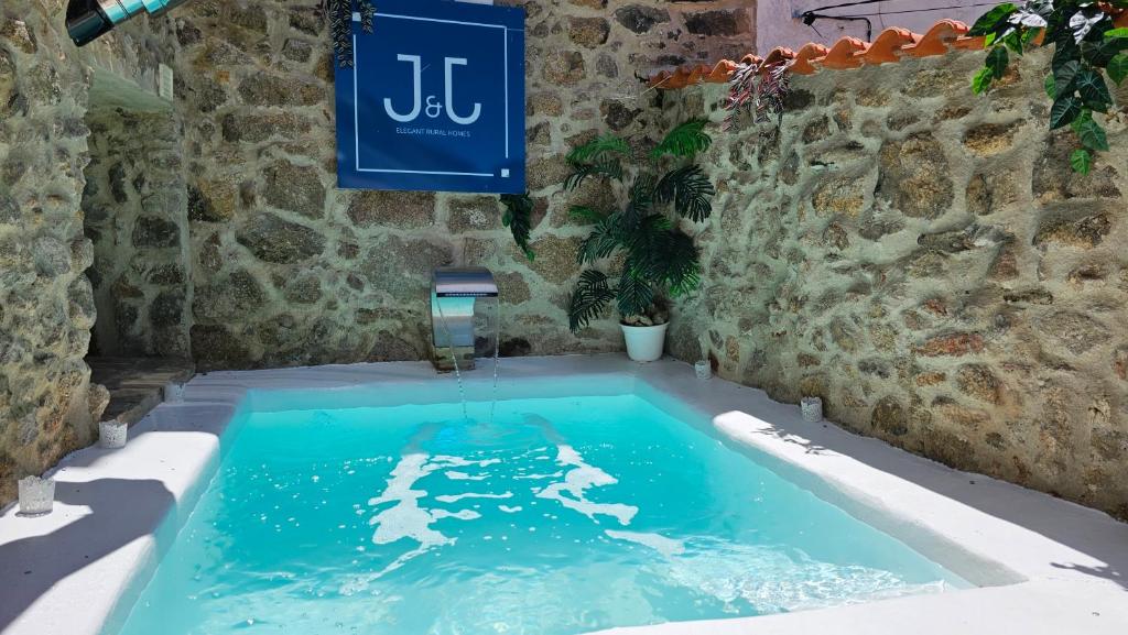 蒙坦切斯El Edén Casas Rurales con Piscina y Jacuzzi的一座带喷泉的石墙游泳池