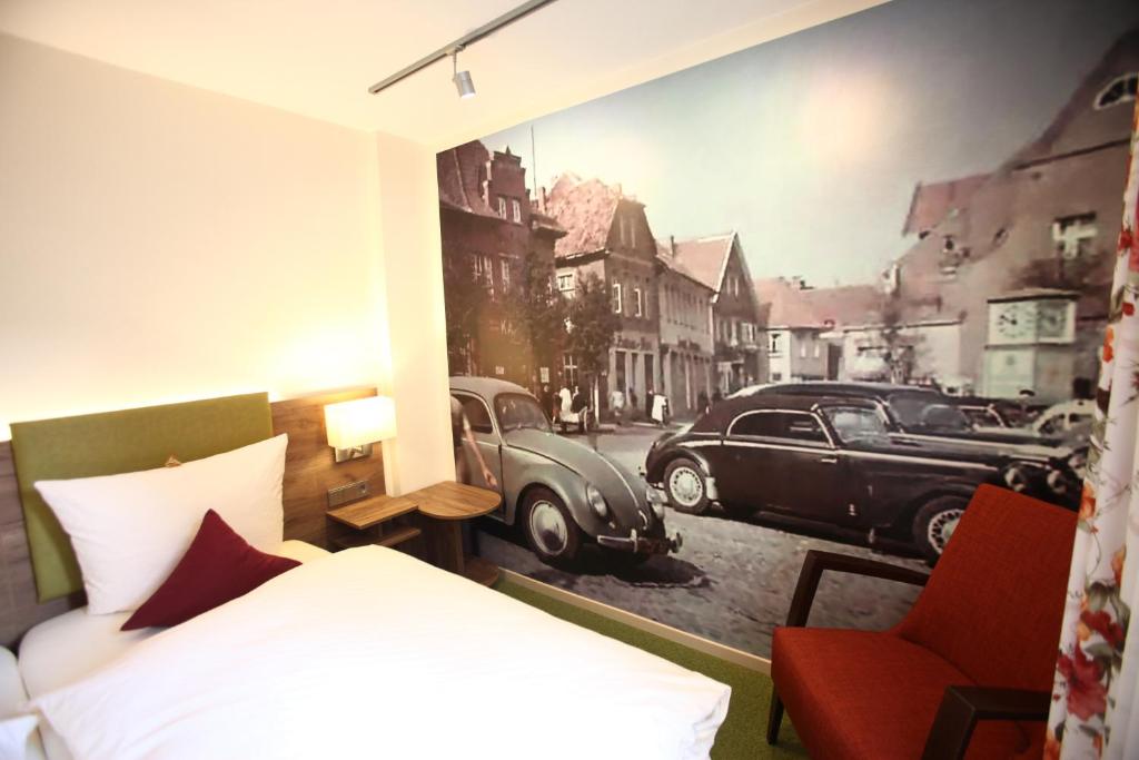 梅彭马克施密特酒店的卧室配有一张床,汽车画