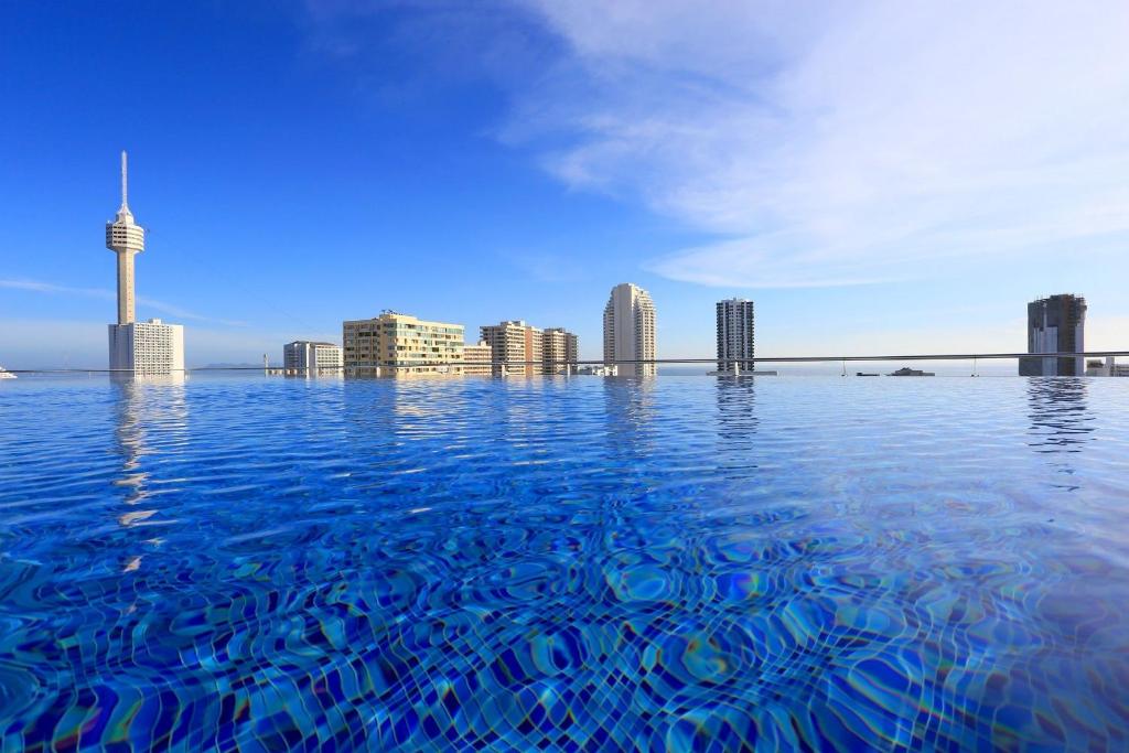南芭堤雅Sirin Exclusive Hotel and Residence的无边泳池享有城市美景。