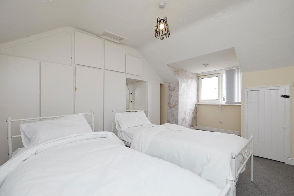 诺丁汉Comfortable 4-Bed House in Hucknall Nottingham的白色客房的2张白色床和吊灯