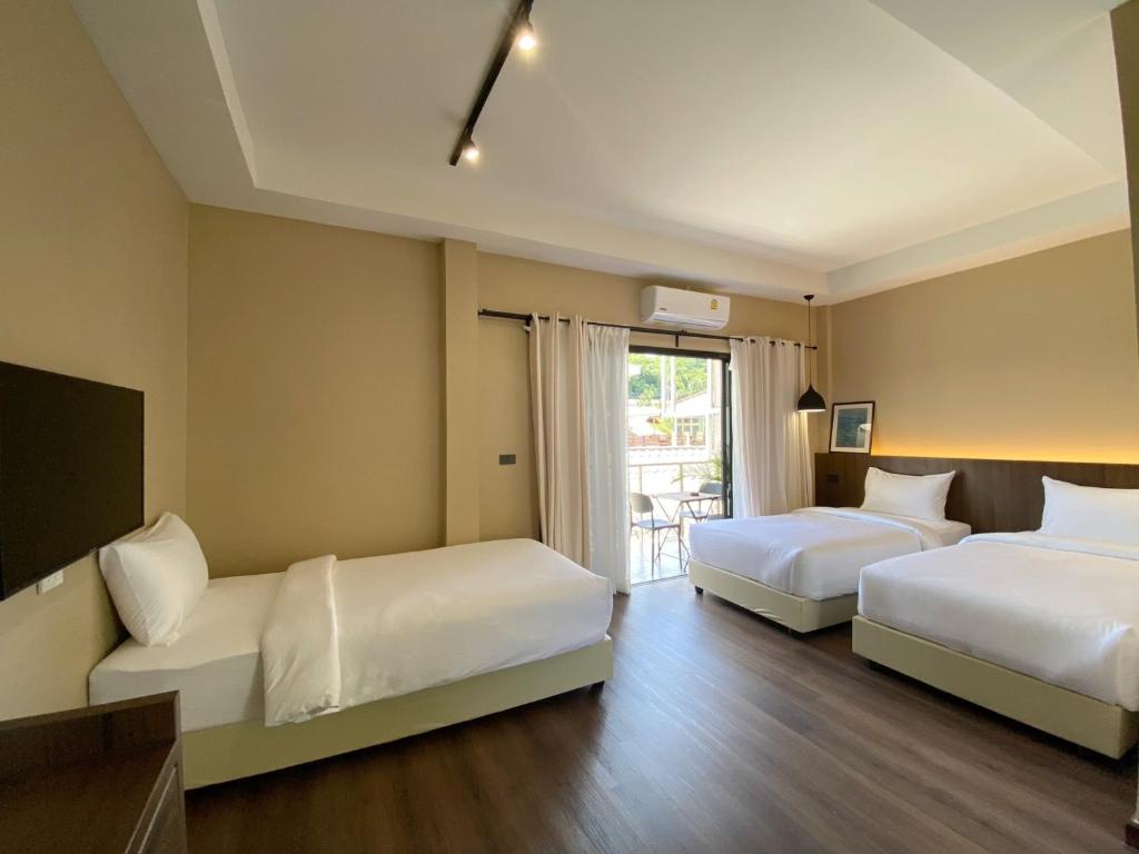 沙美岛Suncloud Hotel Koh Samet的酒店客房设有两张床和窗户。