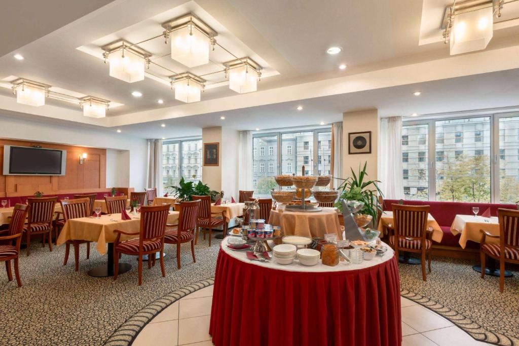 布拉格华美达布拉格市中心酒店的用餐室设有桌椅和窗户。