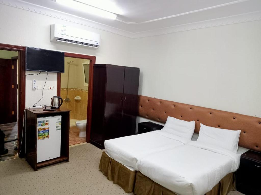 麦加فندق نبض الضيافة 1 - العزيزية الشارع العام的一间带大床的卧室和一间浴室