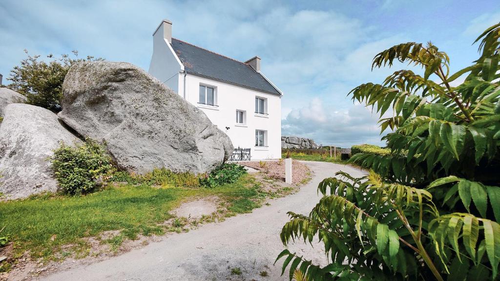 凯卢昂Ty Meham, à 700m de la plage et Meneham, grand terrain calme的前面有一块大石头的白色房子