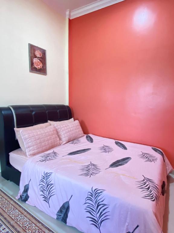 马兰MNOOR HOMESTAY的红色墙壁的房间里一张床位