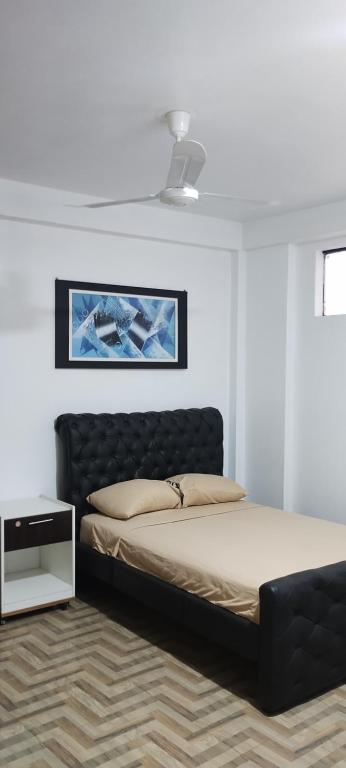 马尔多纳多港Makasai Tambopata 3的一间卧室配有一张带黑色床头板的床