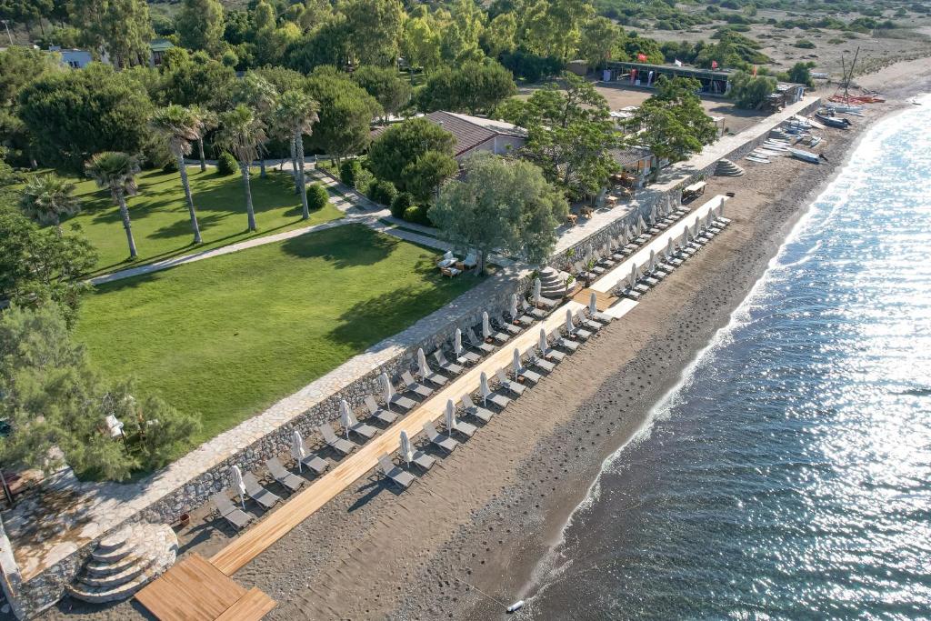 达特恰Datça Dirik Surf Beach Hotel的享有海滩上方的桌椅景致