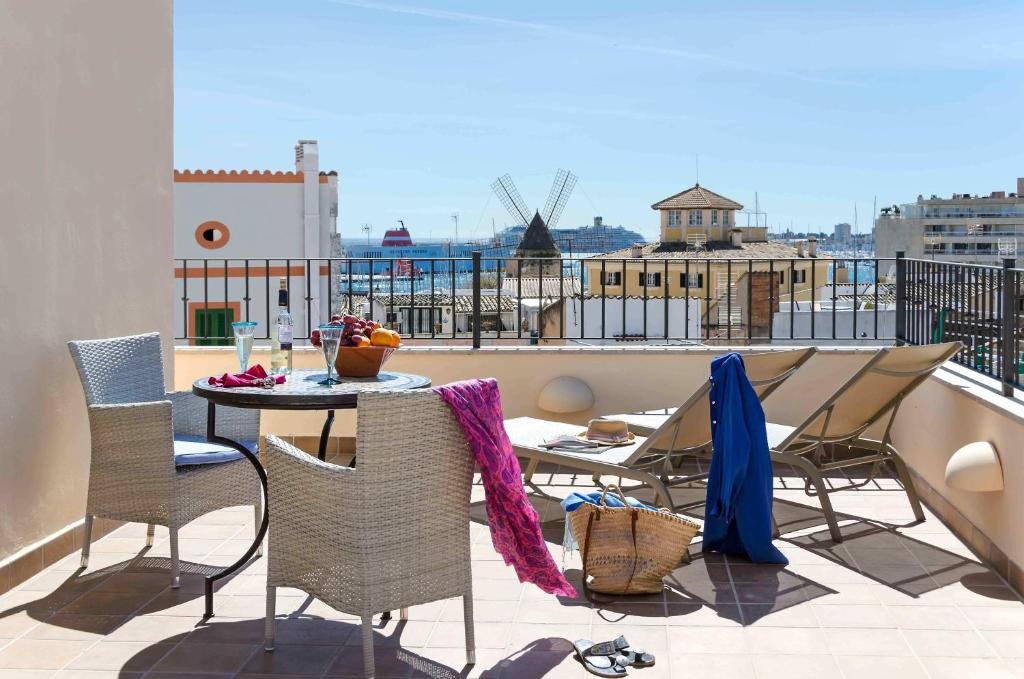 马略卡岛帕尔马卡塔利娜精品公寓式酒店的阳台的天井配有桌椅