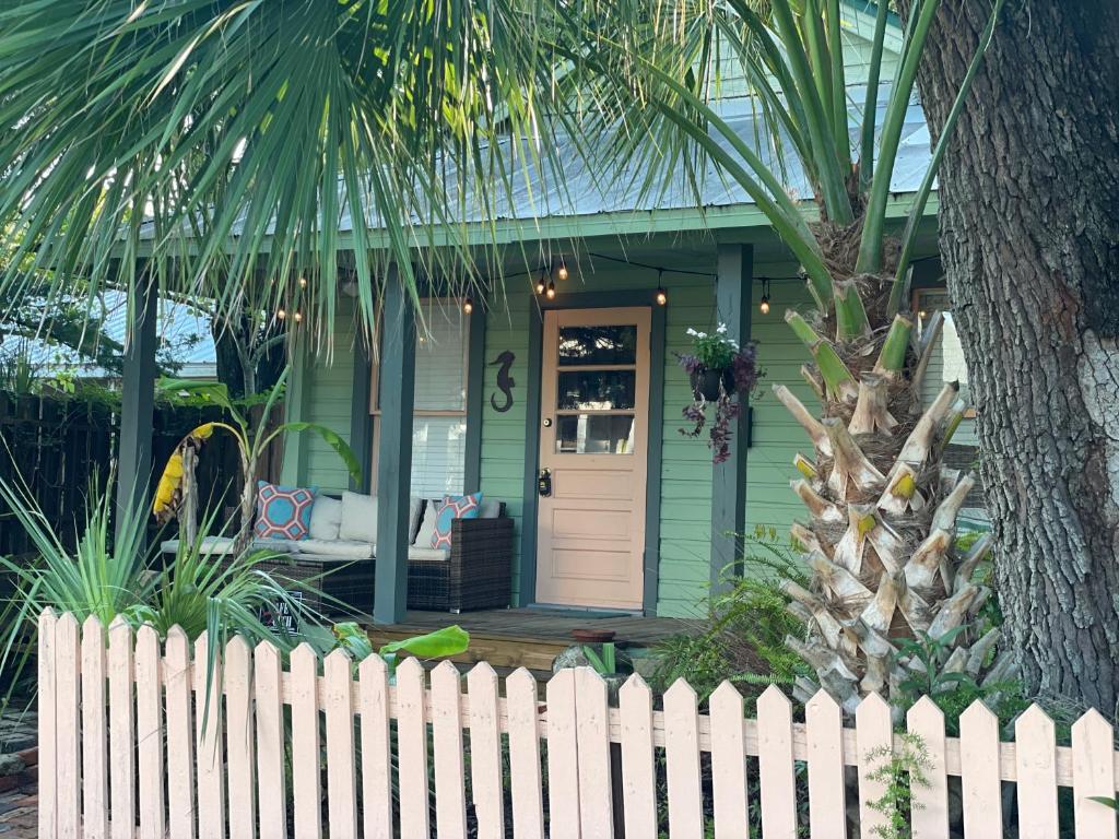 圣奥古斯丁3BR/3BA Charming Key West Style Home in Downtown Saint Augustine的前面有白色围栏的绿色房子