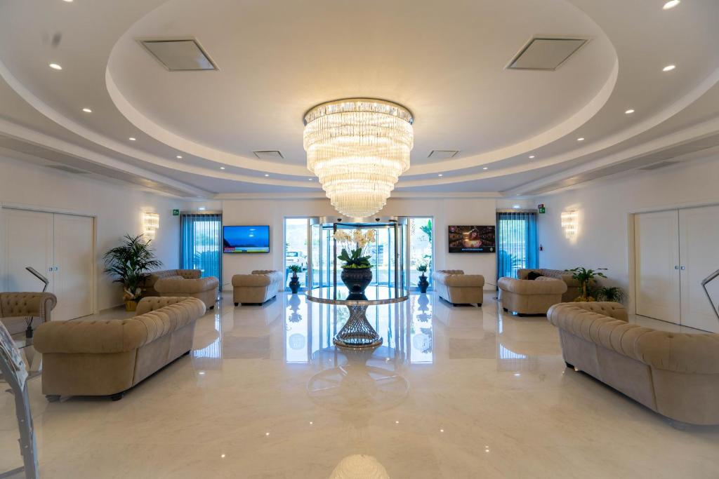 卡坦扎罗丽都PM Hotel的一个带沙发和大吊灯的大型大堂