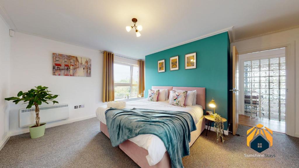 卡迪夫Stunning Cardiff City Apartment! Sleeps 8的一间卧室设有一张床和蓝色的墙壁