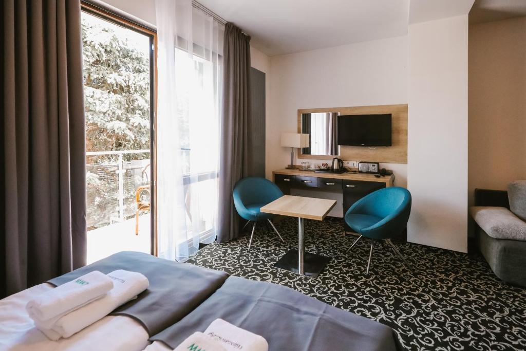 斯维诺乌伊希切Ośrodek Warszawianka的配有一张床、一张书桌和一扇窗户的酒店客房