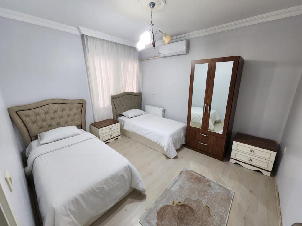 BostancıDeniz manzaralı klimalı daire的一间卧室配有两张床和镜子