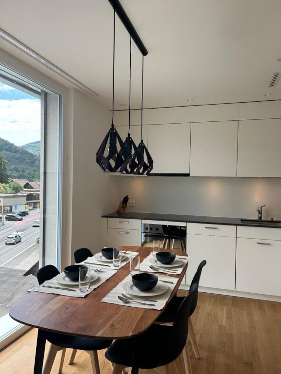 巴尔斯塔尔The R Apartment Engelberg, KLIMA, NEU, Balkon, Parking的厨房配有带黑色椅子的木桌