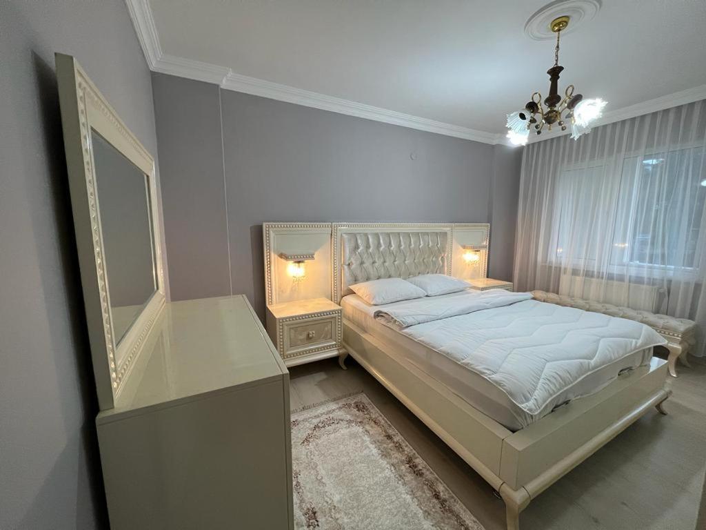 BostancıDeniz manzaralı klimalı daire的一间卧室配有一张大床和一个吊灯。